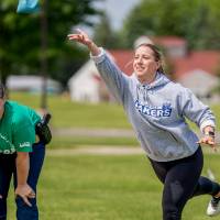 A players throws a bag while a member of the other team looks on